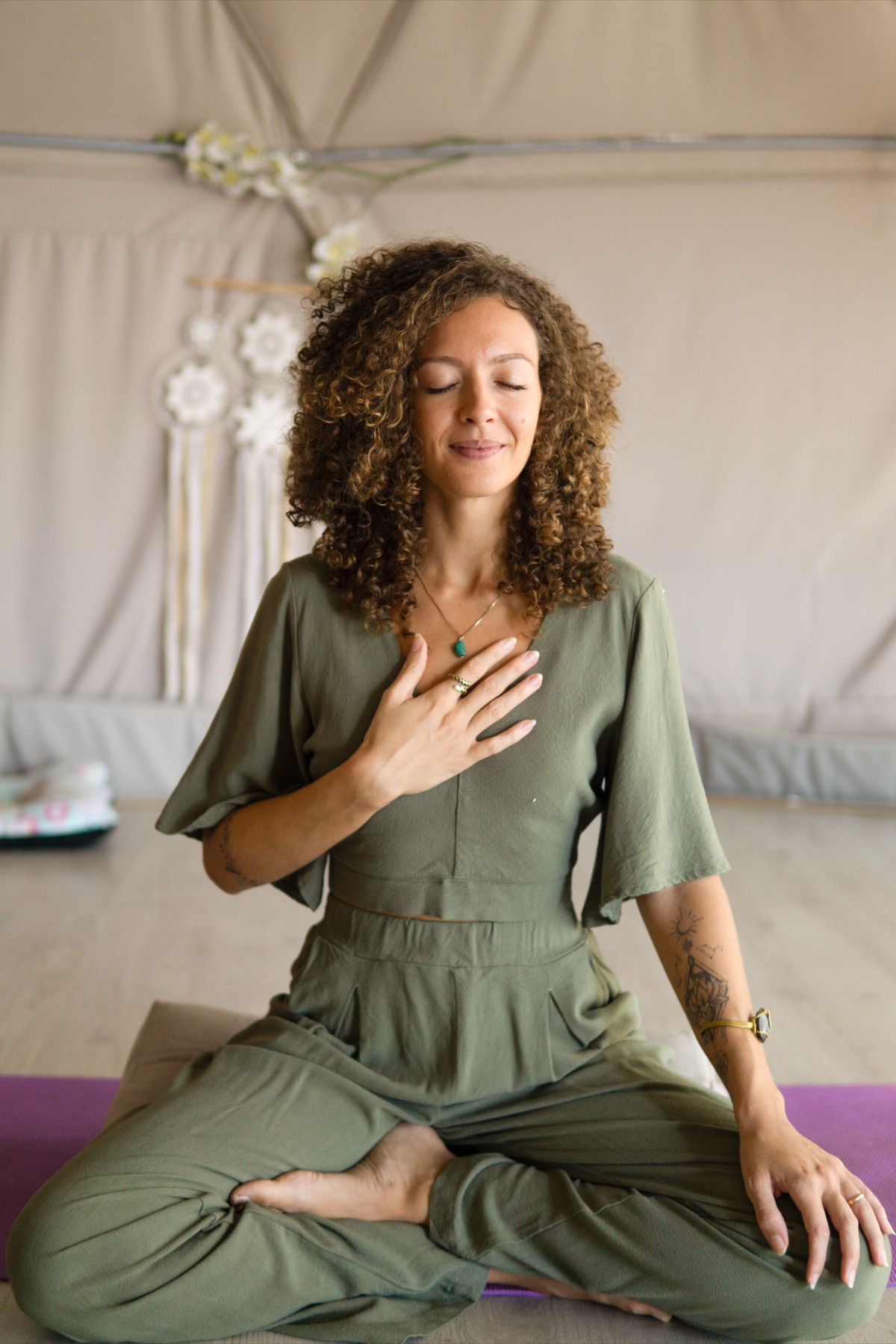 Liza seated in meditation with one hand over her heart
